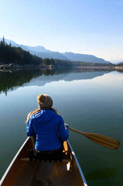 Woman paddling a canoe in BC, Canada. Women adventuring in the great outdoors.