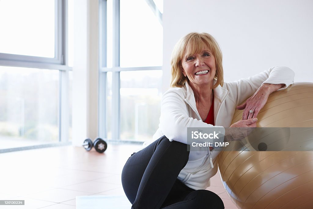 Starszy kobieta odpoczynku na siłowni - Zbiór zdjęć royalty-free (Piłka)