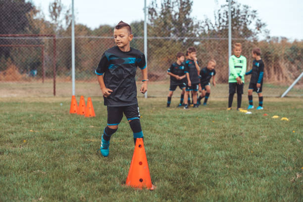 istock Young Player of School Junior Soccer Team Practicing on Grass Field 1201303410