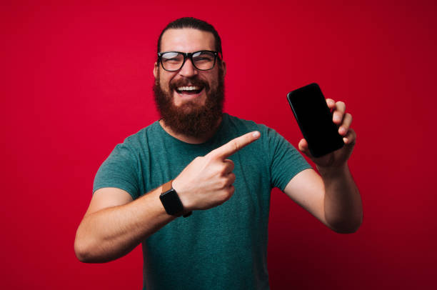 istock Happy bearded man is piting to new awesome mobile 1201303893