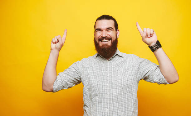 istock Cheerful man in shirt pointing up and up 1201304899
