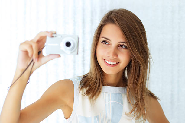 Girl with compact camera girl holding a camera point and shoot camera stock pictures, royalty-free photos & images