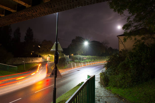 istock Urban Light Trails and Moon at Night 1201307550