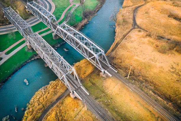 istock Two metal railway bridges over a small river, view from the drone. 1201308587