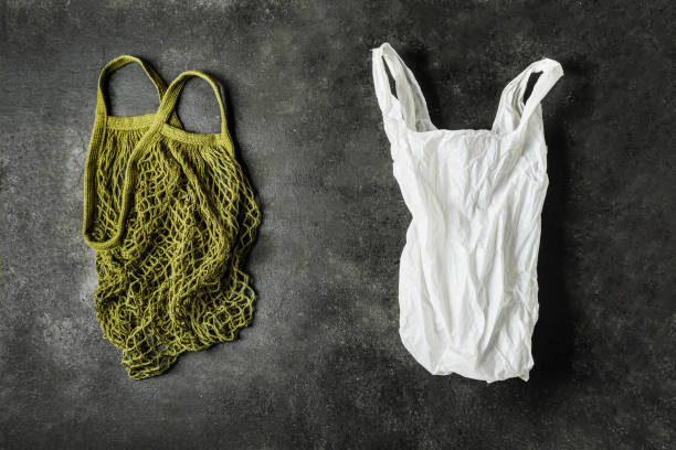 istock A green string bag and a white plastic bag on a black background. The concept of no plastic. Choose an environmental product. 1201311090