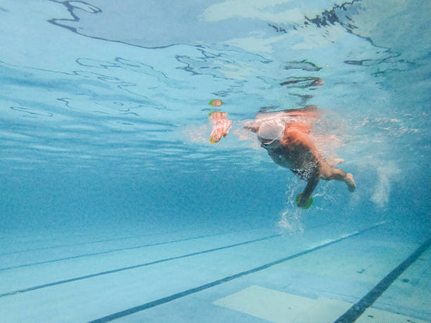 старший человек плавание вольным стилем под водой в бассейне - body care power swimming goggles swimming стоковые фото и изображения
