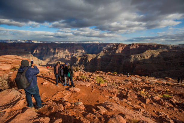 Visitors at the Grand Canyon - Eagle Point Peach Springs, USA - December 28, 2019. A group of people pose for their own picture in front of the Grand Canyon. unesco organised group photos stock pictures, royalty-free photos & images