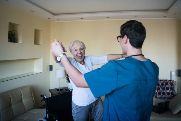 uma mulher idosa deficiente está dançando com seu jovem médico - nurse ethnic doctor real people - fotografias e filmes do acervo