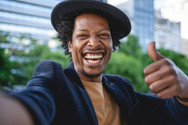 istock Cheerful African American holding a thumbs up while doing a selfie 1201317292