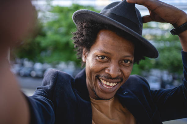 istock Cheerful African American greeting with a hat while doing a selfie 1201317950