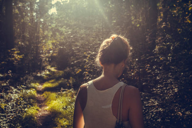 istock Woman walking alone in the forest 1201319318