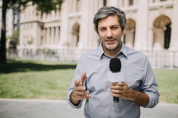 istock Journalist with microphone on the city streets 1201325238