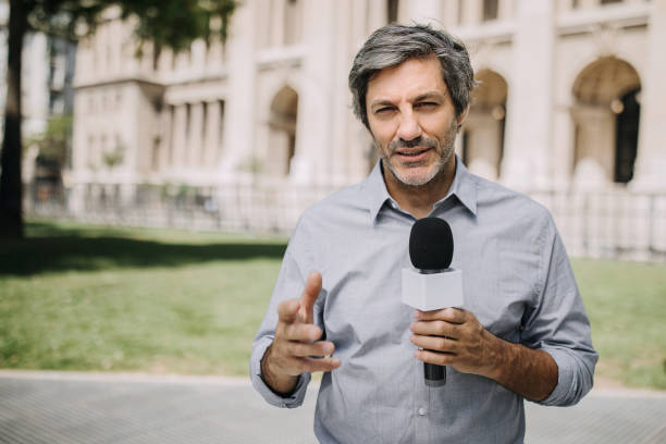 Journalist with microphone on the city streets Journalist with microphone on the city streets tv reporter photos stock pictures, royalty-free photos & images