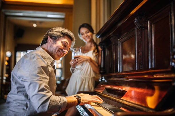 istock Handsome man playing a piano for his wife at a restaurant 1201326070