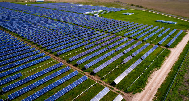 solar power plant producing solar generation above rows and rows of solar panels - town imagens e fotografias de stock