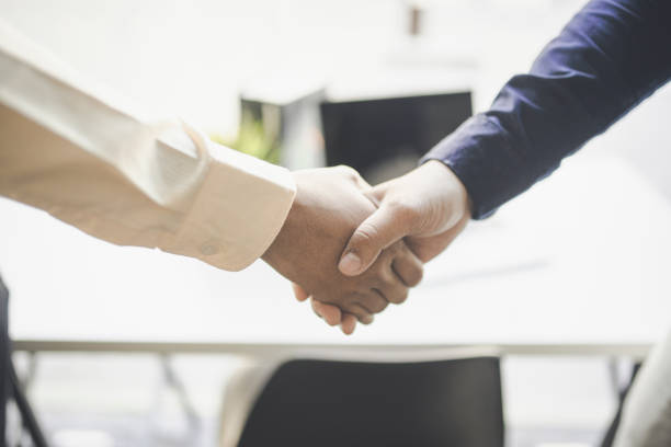 istock Business partners holding hands with trust commitment for reach successful achievement. 1201328982