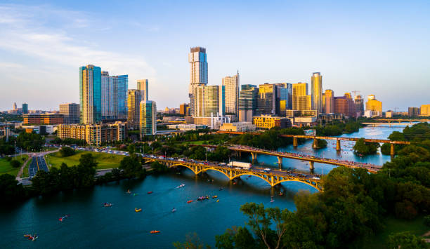 Golden Austin Texas sunset over Cityscape Awei drone views at golden hour Austin Texas sunset of a modern future city above green landscape cityscape above Town lake or Lady Bird Lake bridges and towers packing with kayakers colorado river photos stock pictures, royalty-free photos & images