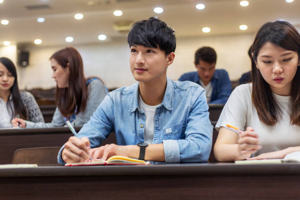 studente universitario che presta attenzione in classe - japanese ethnicity college student student asian ethnicity foto e immagini stock