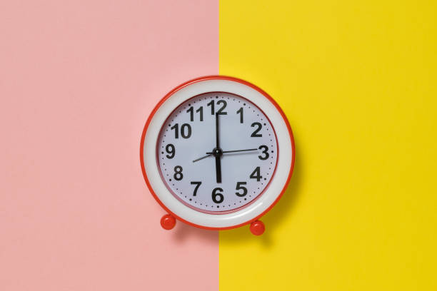 istock Clock with hands on a yellow and pink background. 1201337284