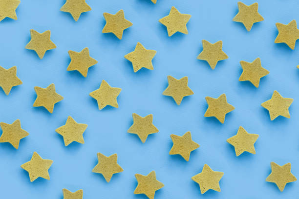 istock Yellow stars on blu background, place for text. pink cookies. Copy space. Mock up 1201339457