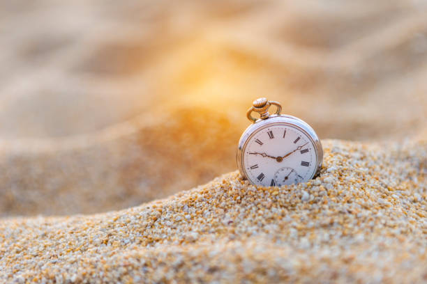 istock Vintage watch on the sand, lost in time 1201341009