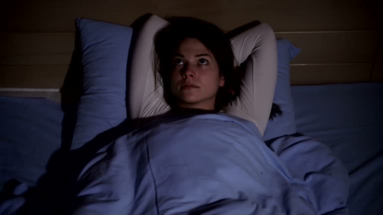 Woman lying in bed suffering from insomnia