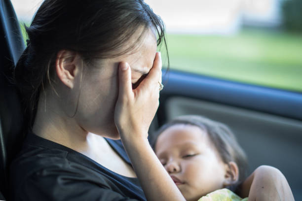 стресс усталая мать страдает послеродовой депрессией, держа своего ребенка. - baby mother sleeping child стоковые фото и изображения