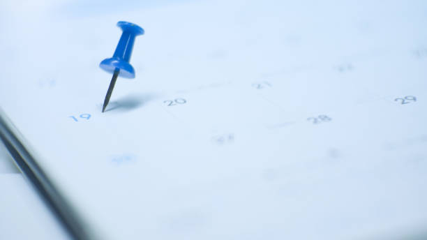 istock Close up  blue pin marking on calendar planning concept with blue tone. 1201346361