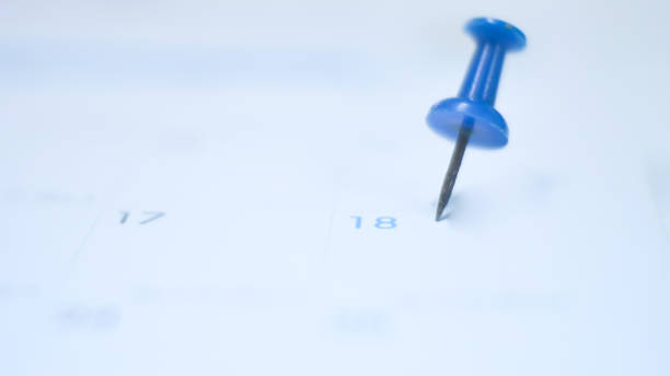 istock Close up  blue pin marking on calendar planning concept with blue tone. 1201346372