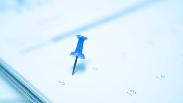 istock Close up  blue pin marking on calendar planning concept with blue tone. 1201346376