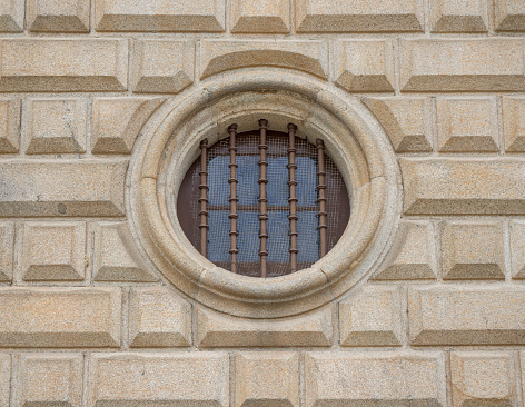 Porthole style window on stone wall