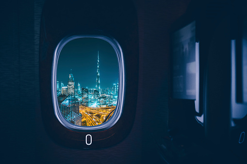 Dubai city seen through an aircraft window at night.