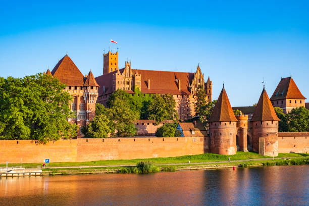 Panoramic view of the defense walls and towers of the Medieval Teutonic Order Castle in Malbork, Poland Malbork, Pomerania / Poland - 2019/08/24: Panoramic view of the defense walls and towers of the Medieval Teutonic Order Castle in Malbork, Poland from across the Nogat river marienburg stock pictures, royalty-free photos & images