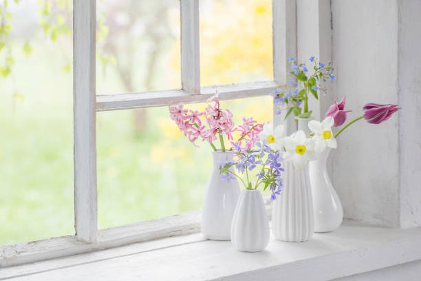 istock spring flowers in white vase on old windowsill 1201352333