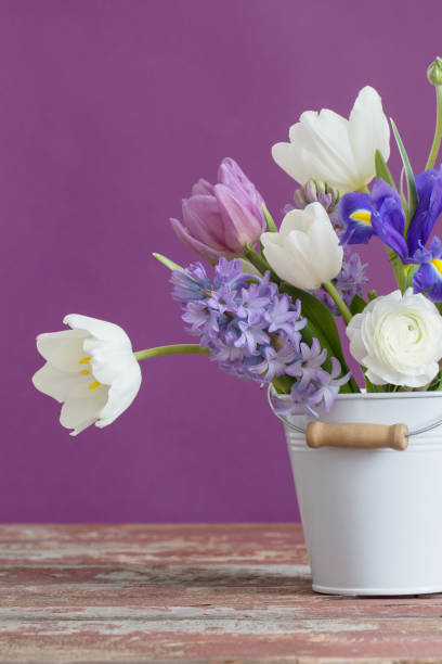 istock spring flowers in bucket on pink background 1201352370