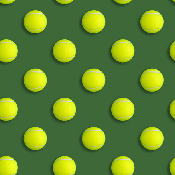 istock Seamless pattern with yellow tennis balls on a green background 1201354185