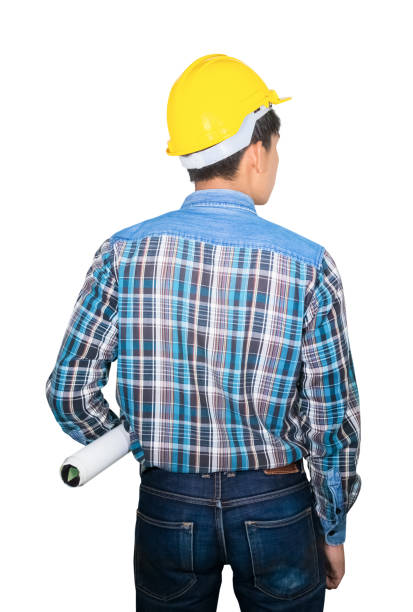 istock Engineering holding rolled blueprints back turned and wear yellow safety helmet plastic isolated on white background 1201356811
