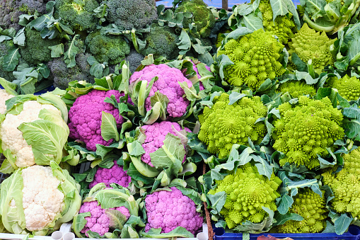 Different kinds of cauliflower and broccoli for sale at a market