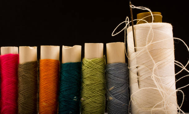 istock Colorful cotton yarns on rolls for sewing. Thread spools used in fabric and textile industry 1201363299
