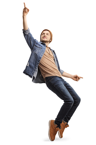 Full length shot of a young man dancing and looking up isolated on white background