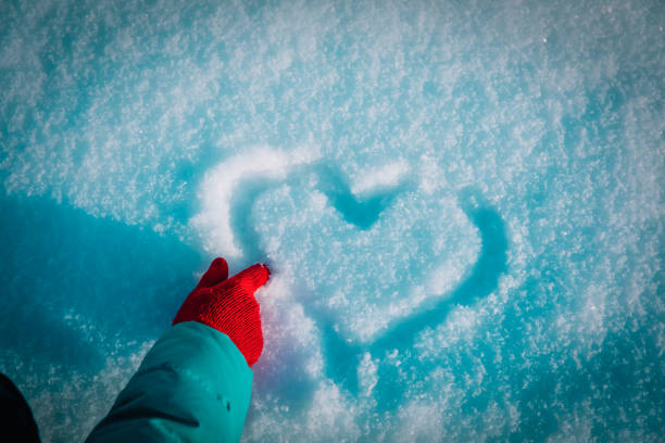 drawing heart on snow, love winter concept, winter nature
