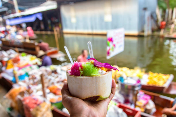 crème glacée douce de noix de coco dans la cuillère fraîche de noix de coco et en plastique au marché flottant de damnoen saduak - damnoen saduak floating market photos et images de collection