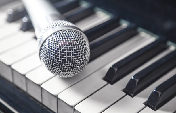 istock Microphone on piano keyboard. White and black. Music 1201381460