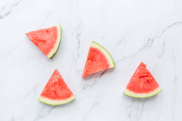 istock Creative flat lay top view of fresh watermelon slices on white marble background with copy space. Minimal summer fruits pattern for blog or recipe book. Healthy food and diet concept 1201383214