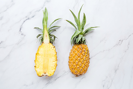 Creative layout made of pineapple on white marble background. Tropical flat lay. Food concept. Mockup, top view, place for text, overhead. Healthy food concept