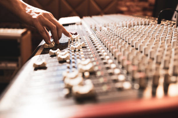 istock male professional sound engineer hand adjusting audio level on mixing console in recording studio 1201385875