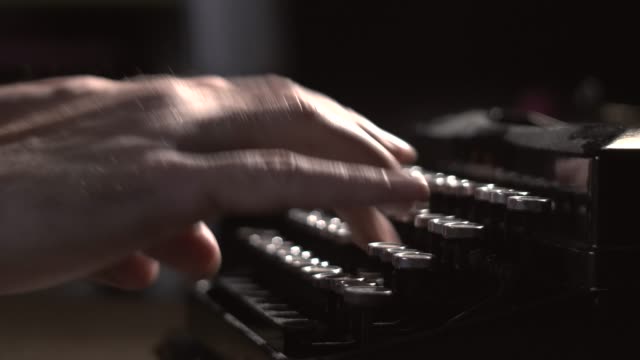 writer types on typewriter keyboard