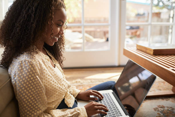 istock Smiling young woman working on her laptop at home 1201387082