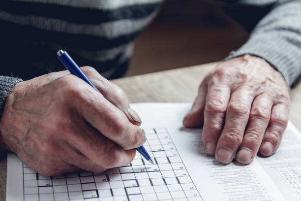 istock Senior solves sudoku or a crossword puzzle to slow the progressi 1201387194