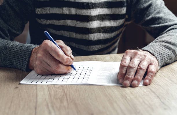 istock Senior solves sudoku or a crossword puzzle to slow the progressi 1201387272